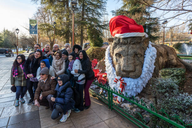 Tourists take photos of a lion statue in the Middle Atlas region of Ifrane, Morocco